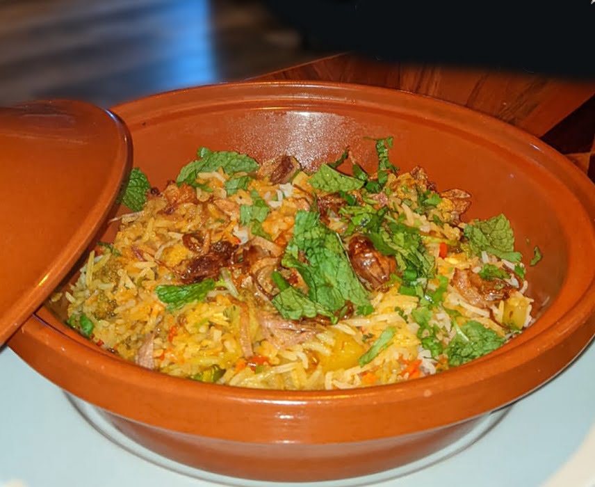 Biryani de légumes servi dans un récipient métallique.